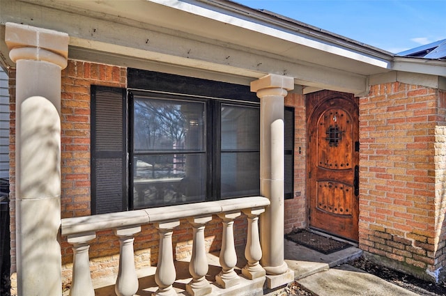 view of exterior entry featuring brick siding