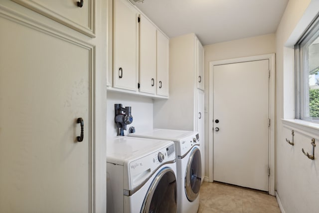 laundry room with baseboards, washer and dryer, light tile patterned floors, and cabinet space