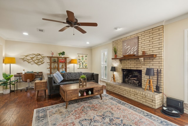 living area with ornamental molding, wood finished floors, visible vents, and a ceiling fan