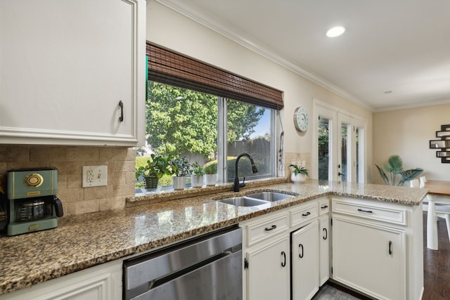 kitchen featuring white cabinets, stainless steel dishwasher, a sink, stone counters, and crown molding