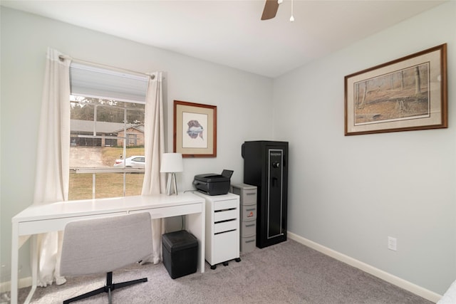 home office featuring baseboards, ceiling fan, and light colored carpet