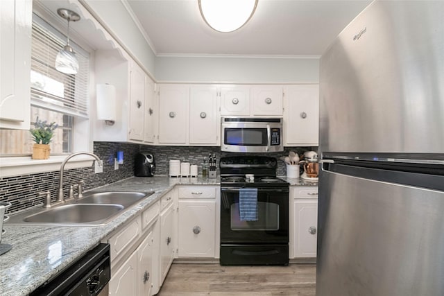 kitchen featuring stainless steel appliances, a sink, white cabinets, decorative backsplash, and crown molding