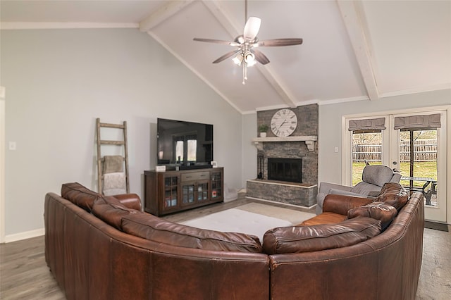 living room with baseboards, french doors, ceiling fan, a stone fireplace, and beam ceiling