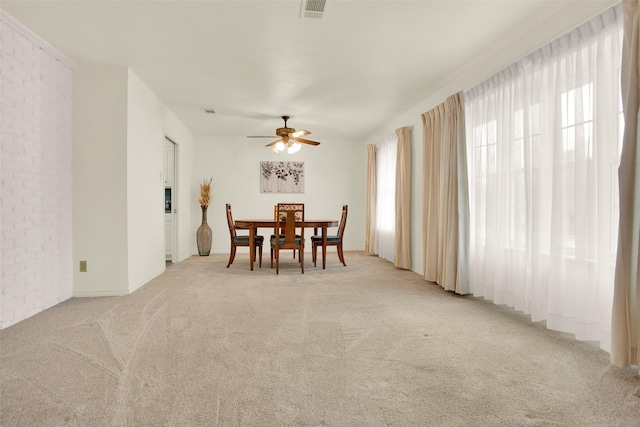 dining room featuring light carpet, visible vents, and a ceiling fan