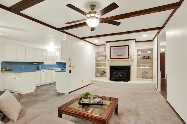 living area with light carpet, baseboards, built in features, ornamental molding, and beamed ceiling