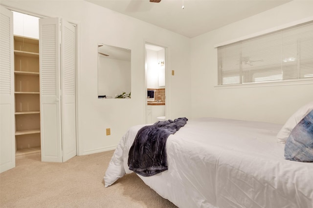 carpeted bedroom with ceiling fan and ensuite bath