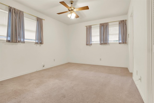 spare room with light carpet, ceiling fan, and baseboards