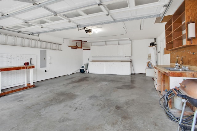 garage featuring a sink, electric panel, gas water heater, and a workshop area