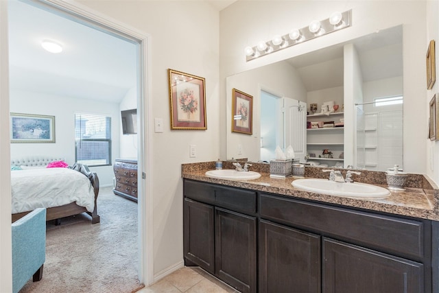 full bathroom with vaulted ceiling, double vanity, a sink, and ensuite bathroom