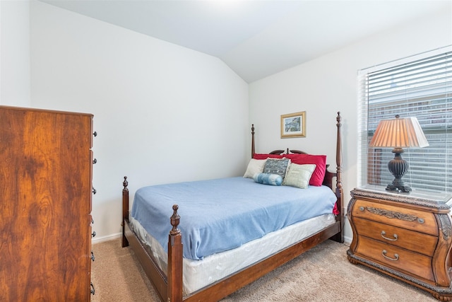 bedroom featuring lofted ceiling, baseboards, and light colored carpet