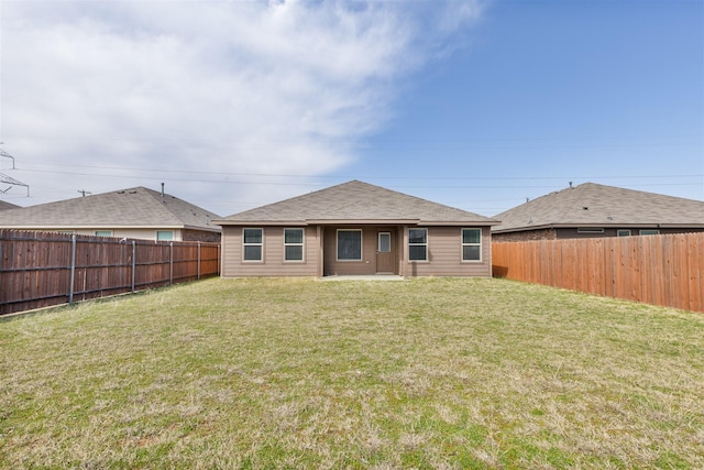 rear view of property with a lawn and a fenced backyard