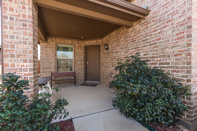 property entrance featuring brick siding