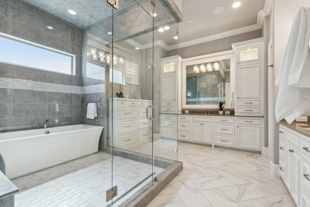 full bathroom featuring a freestanding tub, vanity, marble finish floor, ornamental molding, and a shower stall