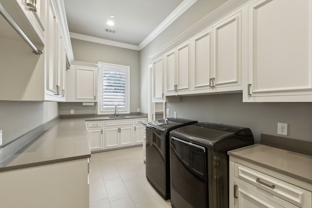 laundry room with a sink, visible vents, washer and dryer, ornamental molding, and cabinet space