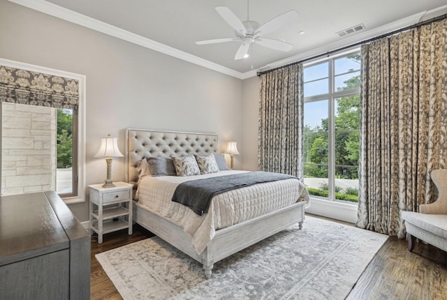 bedroom featuring a ceiling fan, dark wood finished floors, visible vents, and crown molding