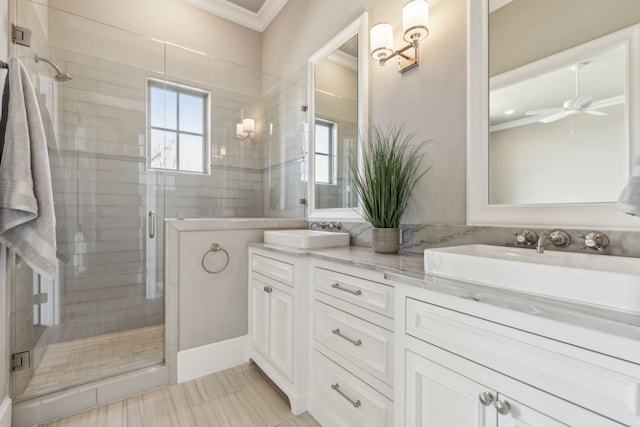 full bath with crown molding, a sink, a shower stall, and double vanity