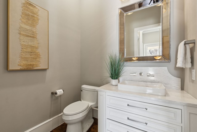 half bathroom featuring vanity and toilet