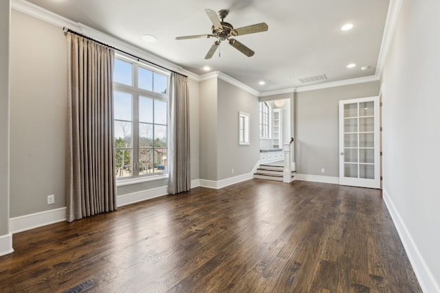 spare room with crown molding, baseboards, and wood finished floors