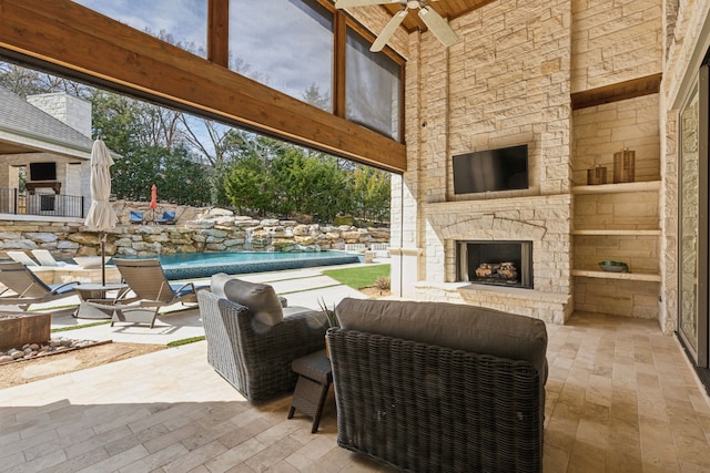 view of patio featuring ceiling fan and an outdoor living space with a fireplace