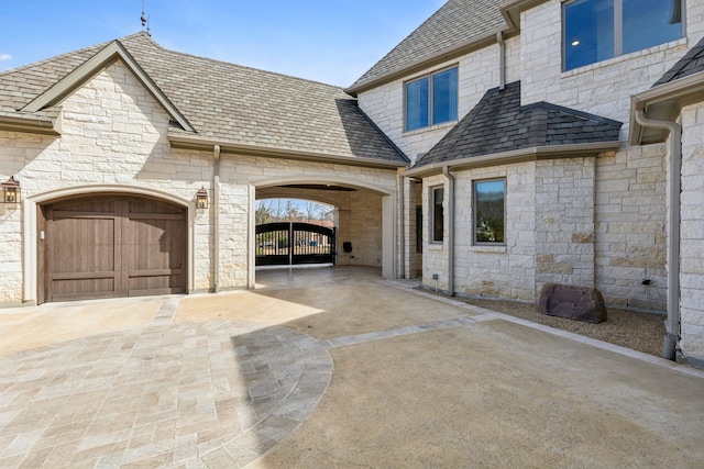 exterior space with a garage, driveway, and a gate