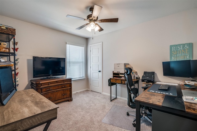 carpeted office space with ceiling fan and baseboards