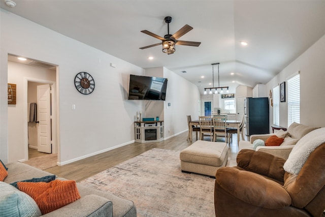 living room with light wood-style floors, baseboards, vaulted ceiling, and recessed lighting