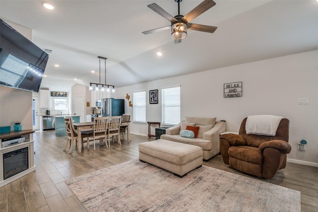 living room featuring recessed lighting, wood finished floors, a ceiling fan, baseboards, and vaulted ceiling