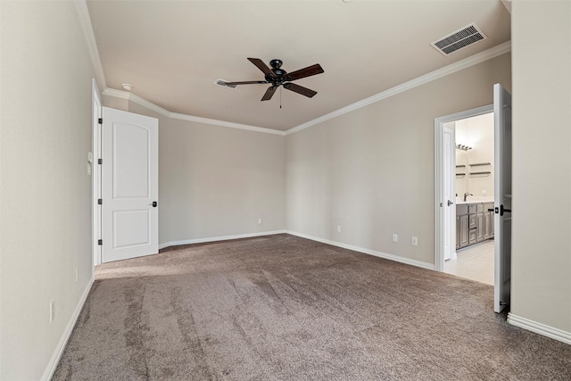 carpeted spare room with baseboards, visible vents, a ceiling fan, and ornamental molding