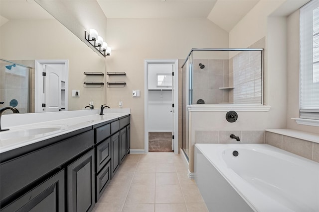 full bathroom featuring a stall shower, vaulted ceiling, tile patterned flooring, and a sink