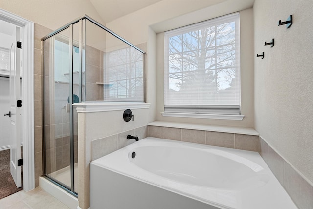 full bathroom featuring a garden tub, a shower stall, and tile patterned floors