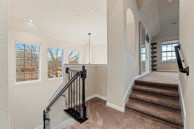 stairs with carpet flooring, visible vents, and baseboards