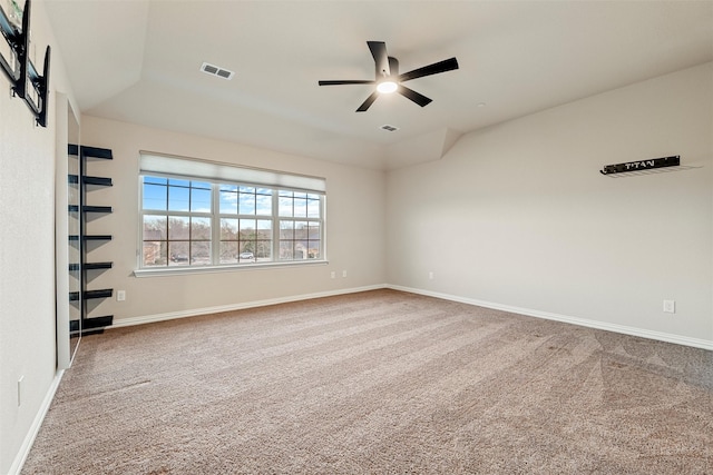 carpeted empty room with a ceiling fan, visible vents, and baseboards