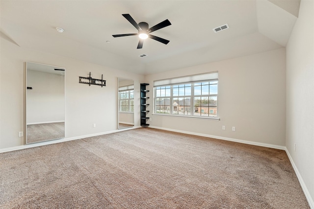 spare room with a ceiling fan, carpet flooring, visible vents, and baseboards