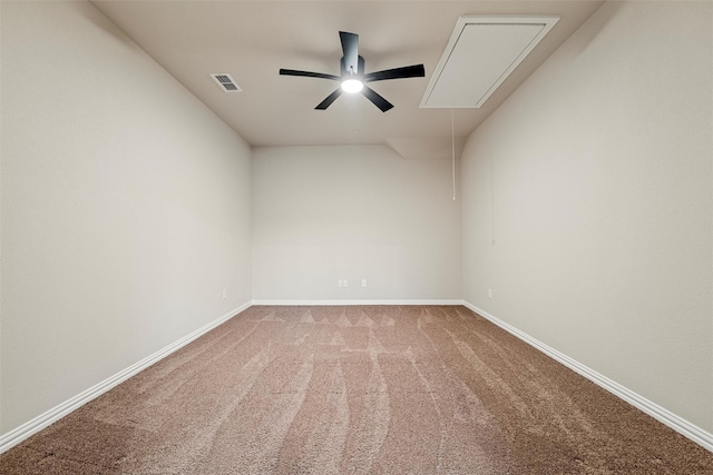 empty room featuring ceiling fan, visible vents, baseboards, carpet, and attic access