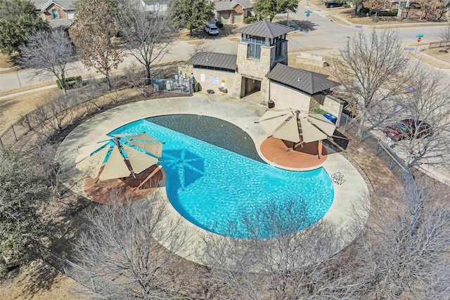 community pool with fence and a patio