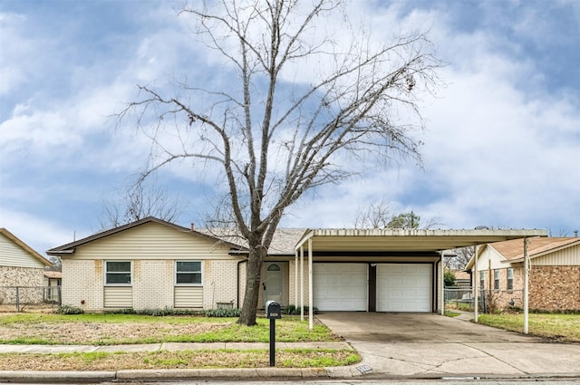 view of front of home with brick siding, driveway, an attached garage, and fence