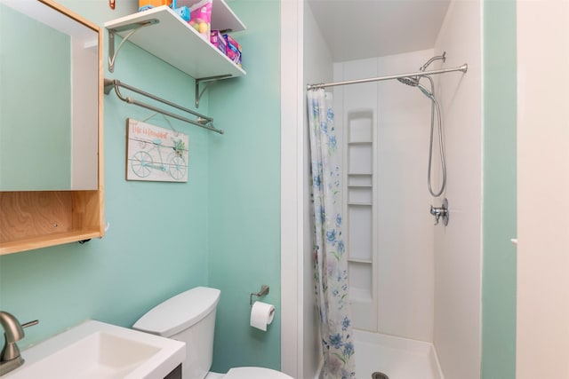 bathroom featuring vanity, a shower stall, and toilet