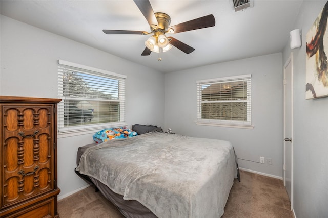 carpeted bedroom with visible vents, ceiling fan, and baseboards