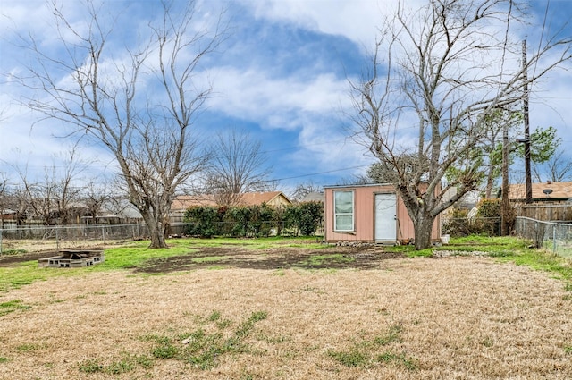 view of yard featuring a storage unit, an outdoor structure, and a fenced backyard