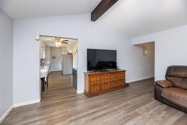 living room featuring a ceiling fan, vaulted ceiling with beams, baseboards, and wood finished floors