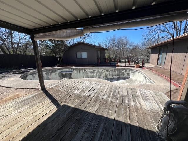 view of swimming pool with a fenced in pool, fence, and a wooden deck