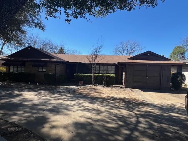 ranch-style home featuring an attached garage and driveway