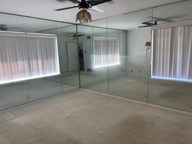 interior space with ceiling fan and carpet flooring