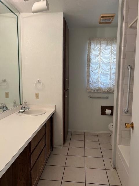 full bath with visible vents, toilet, a bathing tub, tile patterned floors, and vanity