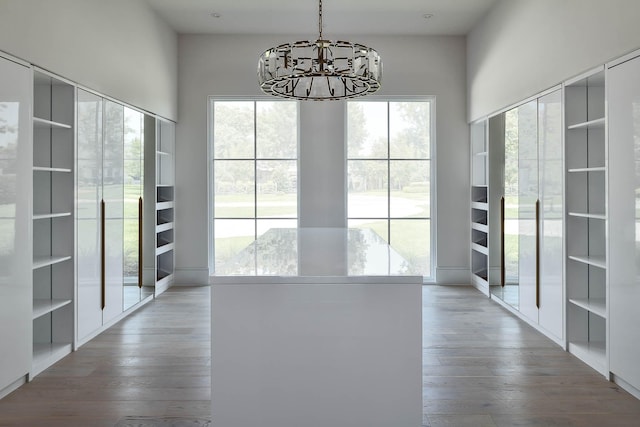 unfurnished dining area with wood finished floors and an inviting chandelier