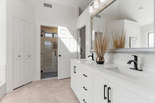 full bath featuring double vanity, a stall shower, visible vents, and a sink