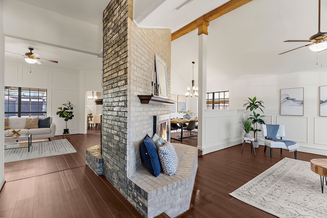 living room with high vaulted ceiling, a decorative wall, and wood finished floors