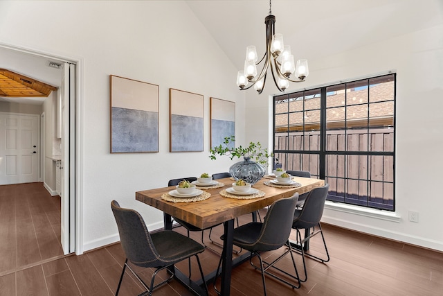 dining area with baseboards, visible vents, dark wood finished floors, lofted ceiling, and an inviting chandelier