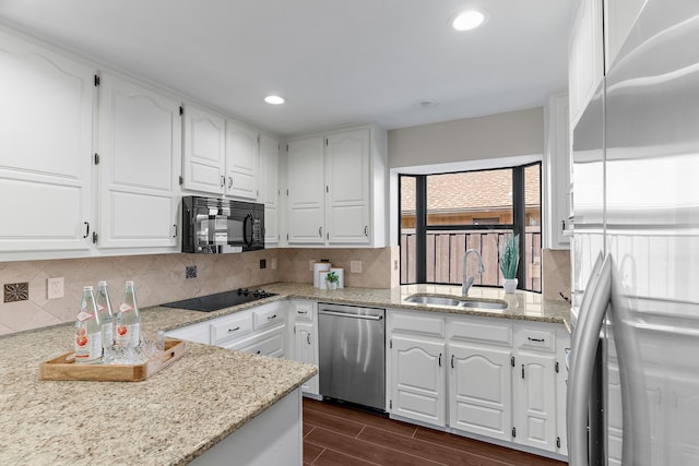 kitchen with wood finish floors, tasteful backsplash, recessed lighting, a sink, and black appliances