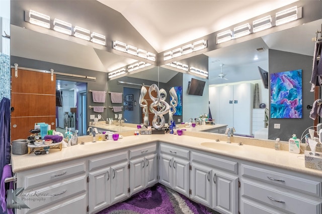 full bathroom featuring ceiling fan, lofted ceiling, a sink, and double vanity